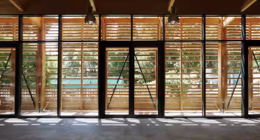 Extension Centre Aéré, grande salle vitrée dont la façade est doublée de lames de bois, double porte centrale