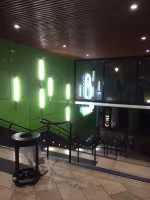 Centre Commercial Bonneveine, escalier éclairé et mur vert à appliques lumineuses près de l'entrée du cinéma