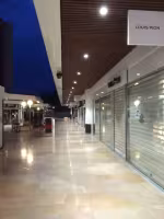 Centre Commercial Bonneveine, galerie bordée de boutiques fermées par des rideaux métalliques