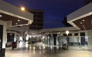 Centre Commercial Bonneveine, allée commerçante la nuit sous des auvents au plafond de bois