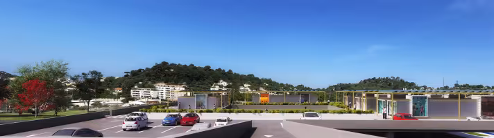 Centre Commercial La Valentine (ESQ), perspective depuis le parking avec kiosques commerciaux à toit végétalisévec panneaux solaires sous un ciel dégagé