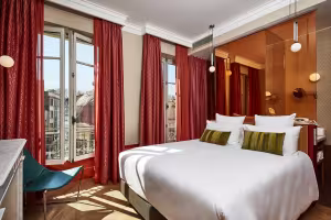 Hôtel de Cambis, chambre à lit blanc, rideaux bordeaux et fauteuil bleu