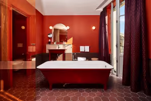 Hôtel de Cambis, salle de bain rouge avec baignoire îlot et carreaux hexagonaux