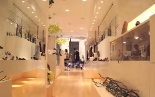Dolce de Limao Concept Store, boutique tout en longueur aux meubles blancs et au parquet clair, avec un lustre vert