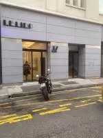 Le Lido Foch, façade grise en pierre à numéro 37 et porte vitrée, moto garée devant