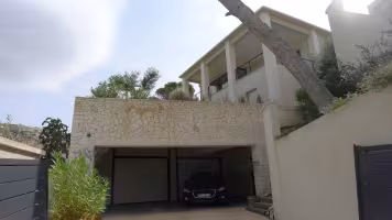 Le Roucas Blanc, garage façade pierre sous terrasse devant la maison