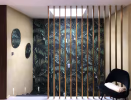 Réhabilitation Le Roucas Blanc, entrée avec papier peint de feuilles de palmier et claustra de lames dorées
