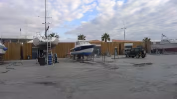 Aire de Carénage Bandol, bateaux sur cales devant une clôture en bois, dans l'aire de carénage