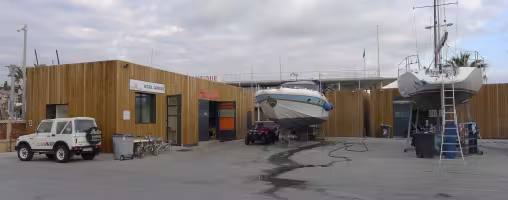 Aire de Carénage Bandol, local d'accueil en bois à côté d'un bateau sur remorque
