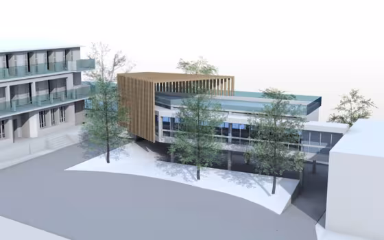 Pouponnière Les Lauriers Roses, perspective du bâtiment à brise-soleil en bois et toiture à bandeau bleu, posé sur pilotis