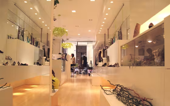 Dolce de Limao Concept Store, boutique tout en longueur aux meubles blancs et au parquet clair, avec un lustre vert