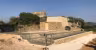 Bastide La Bourrasque, piscine à bords vitrés devant un mur en pierre sèche et une tour