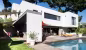 La Panouse, façade sur jardin avec auvent gris, terrasse en bois et mobilier orange